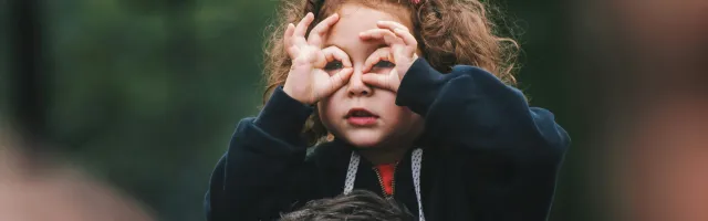 Meisje gebruikt haar handen als verrekijker