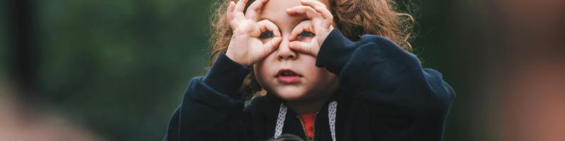 Meisje gebruikt haar handen als verrekijker